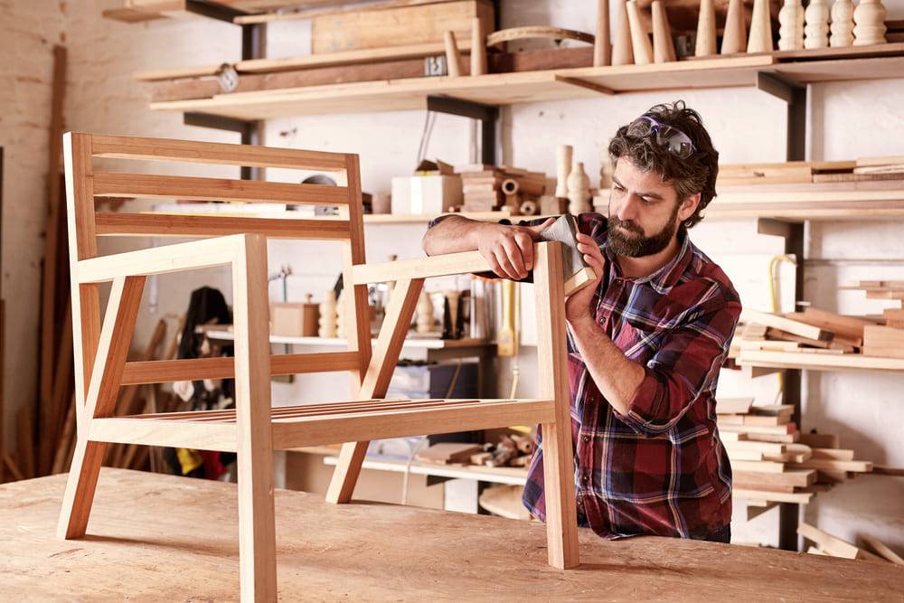 man making a wooden chair in woodworking shop