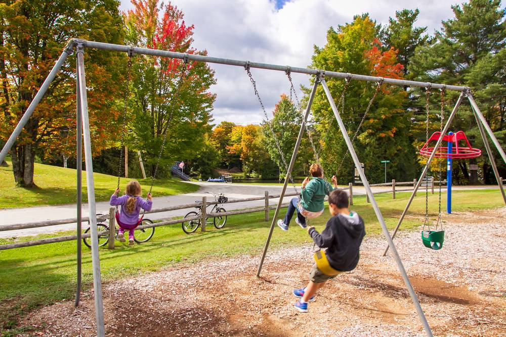 kids on swingset at playground in park